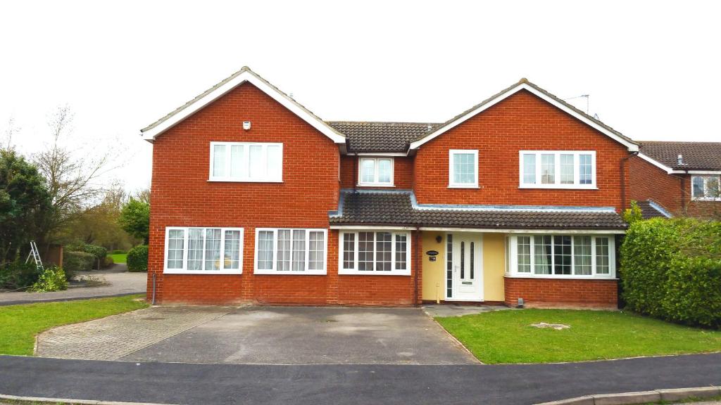 a red brick house with a white door at Fennec Apartments in Cherry Hinton