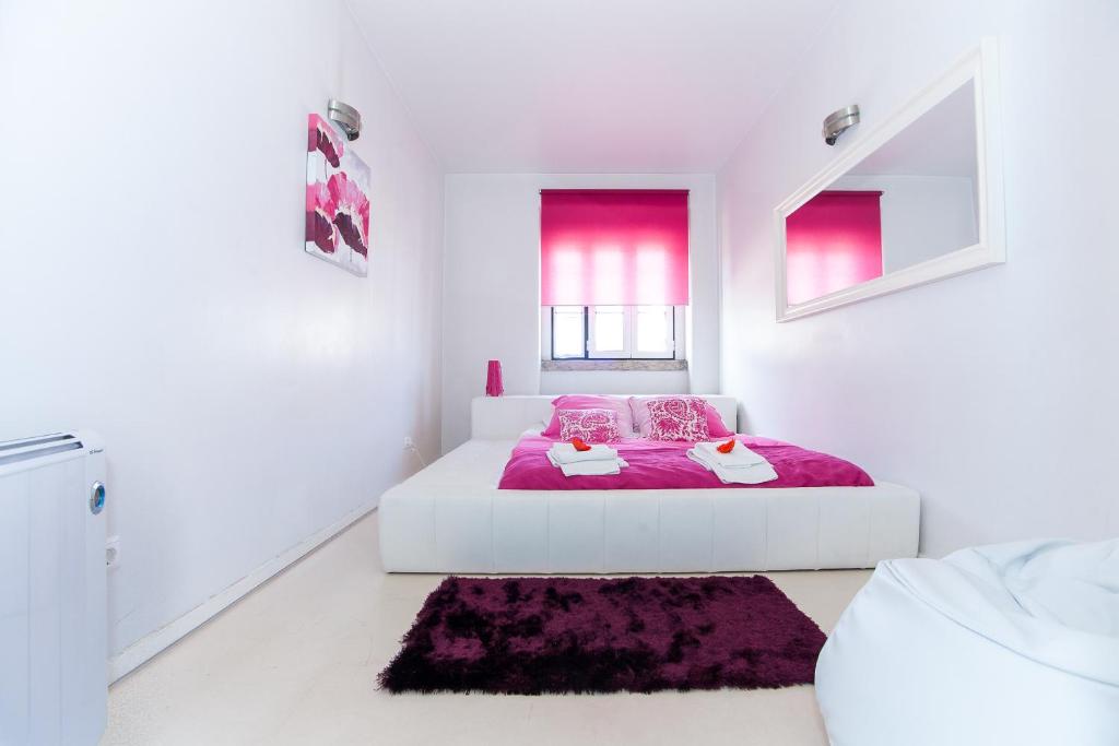 um quarto branco com uma cama com um cobertor roxo em Ana's Design Apartments em Lisboa