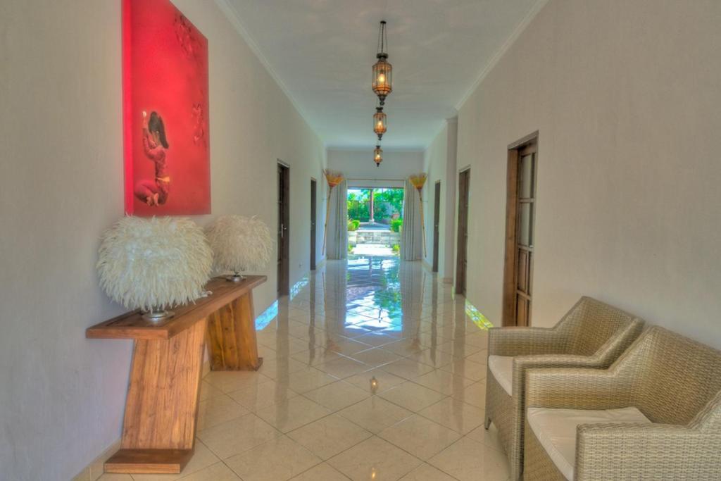 a hallway with two chairs and a red painting on the wall at Villa Nirwana in Lovina