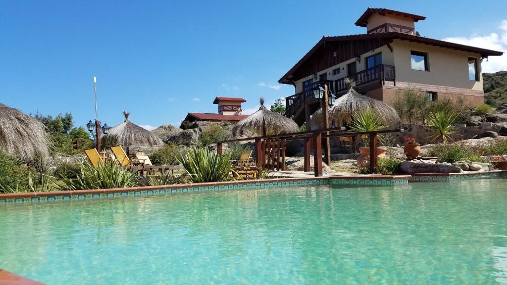 拉工布雷西塔的住宿－Aires Serranos - Suites，一座带游泳池的度假村,位于一座建筑前