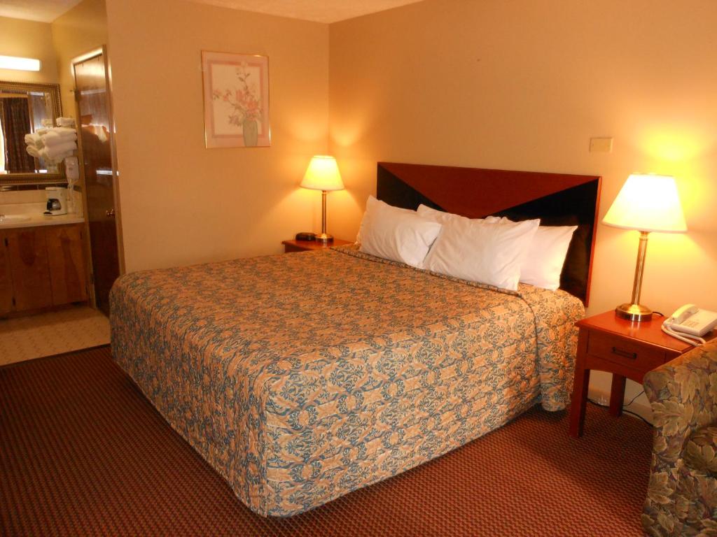 a hotel room with a bed and two lamps at McClellan Inn in Anniston