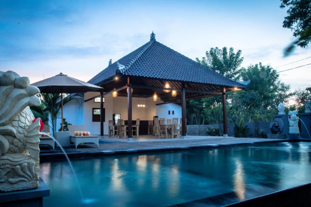 倫邦岸島的住宿－The Niti Hut's Lembongan，房屋旁带凉亭的游泳池