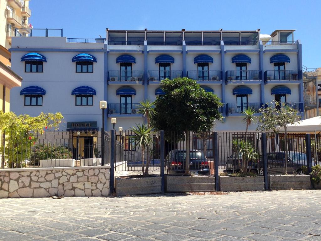 a white building with a fence in front of it at Hotel Al Faro in Licata