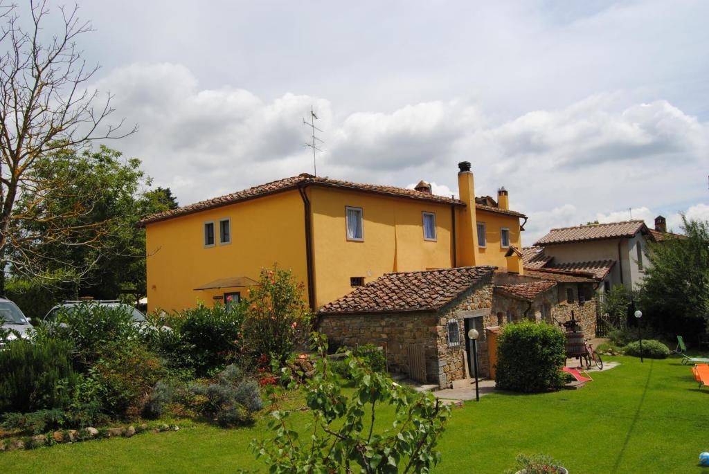 a large yellow house with a yard at La Chiusuraccia in Barberino di Mugello