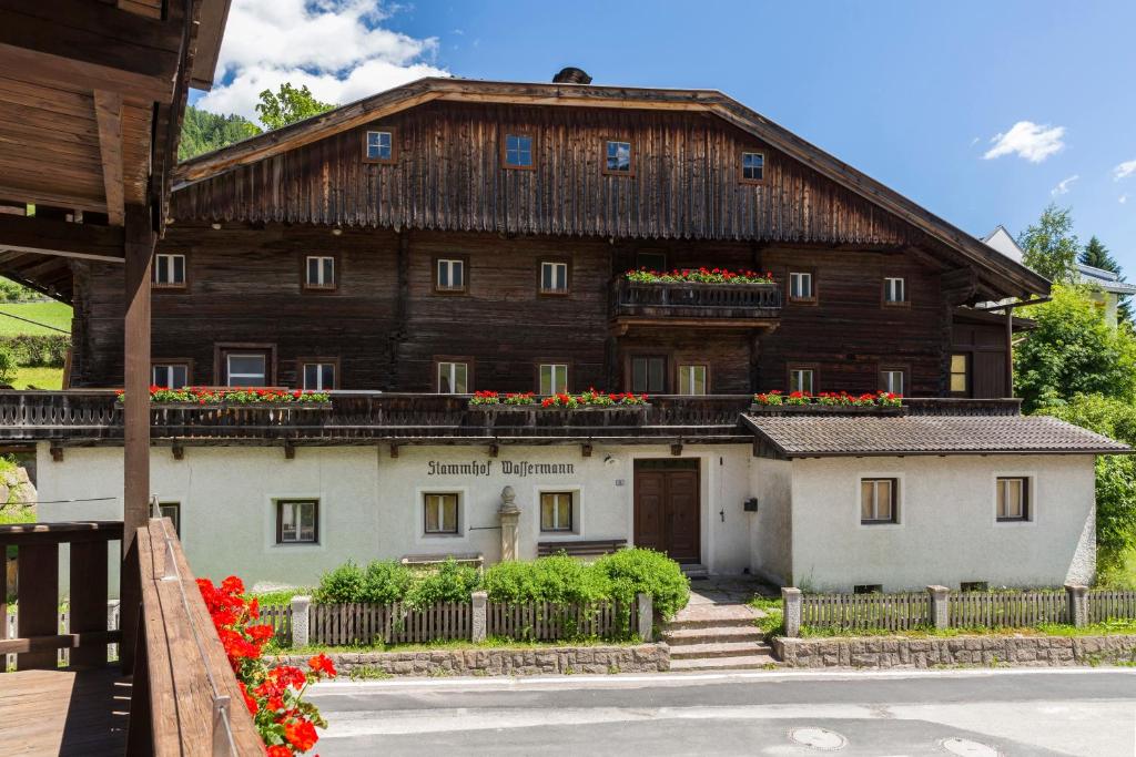 a large wooden building with flowers on the balcony at Wassermann in Sesto
