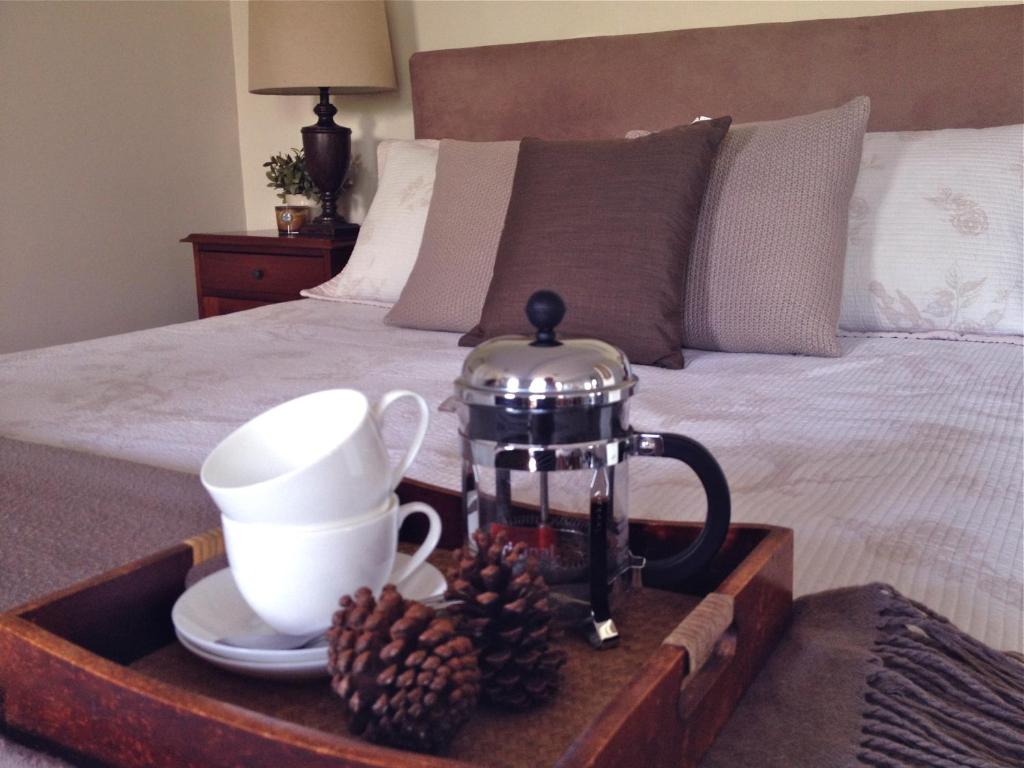 a tray with a tea set on a bed at Jacaranda House Garden Suite in Brisbane