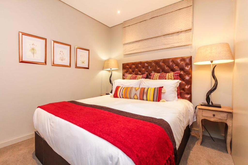 a bedroom with a large bed with a red blanket at Zimbali Suite 521 in Ballito