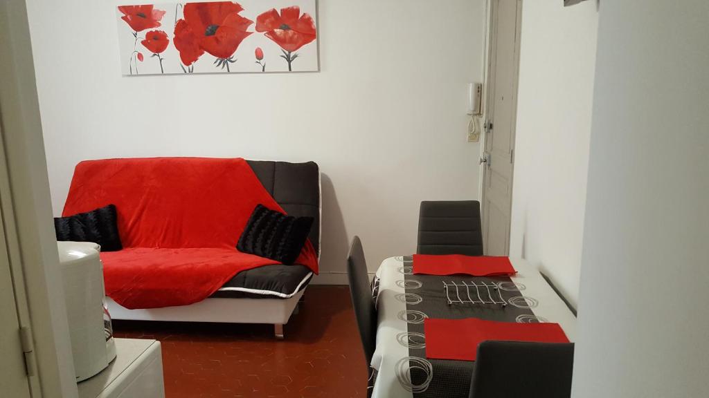 マントンにあるAppartement Le Cernuschi 2Cのリビングルーム(赤毛布付きの椅子付)