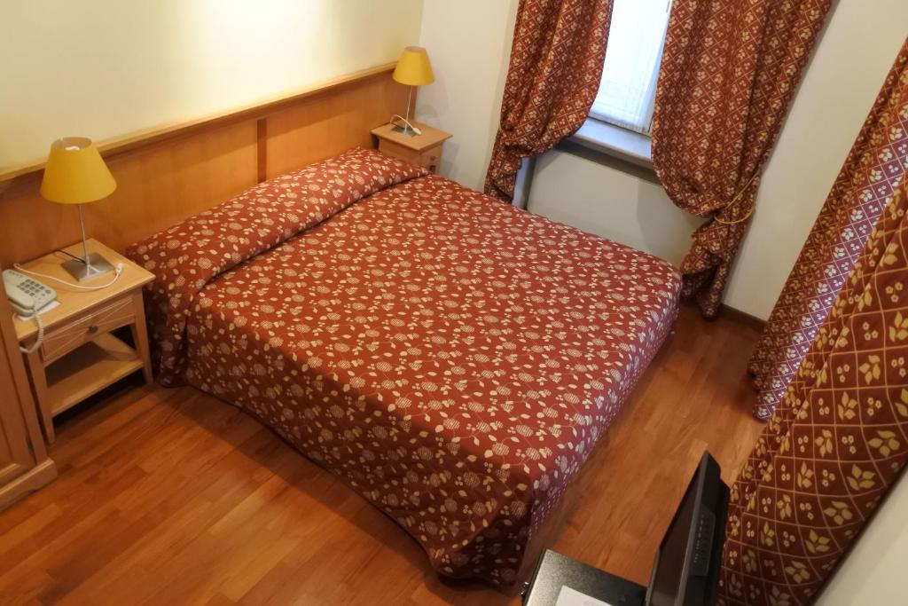 Habitación pequeña con cama y ventana en Gorizia Inn, en Gorizia