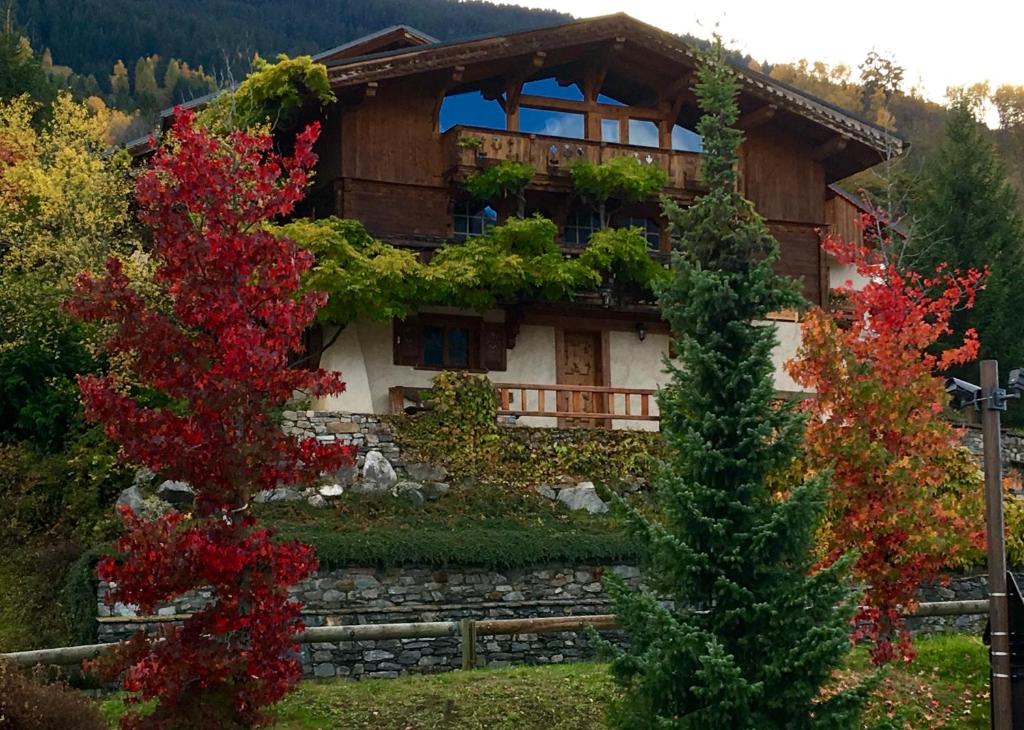 a house in the mountains with a tree at Appartement à Courchevel Saint Bon in Saint-Bon-Tarentaise