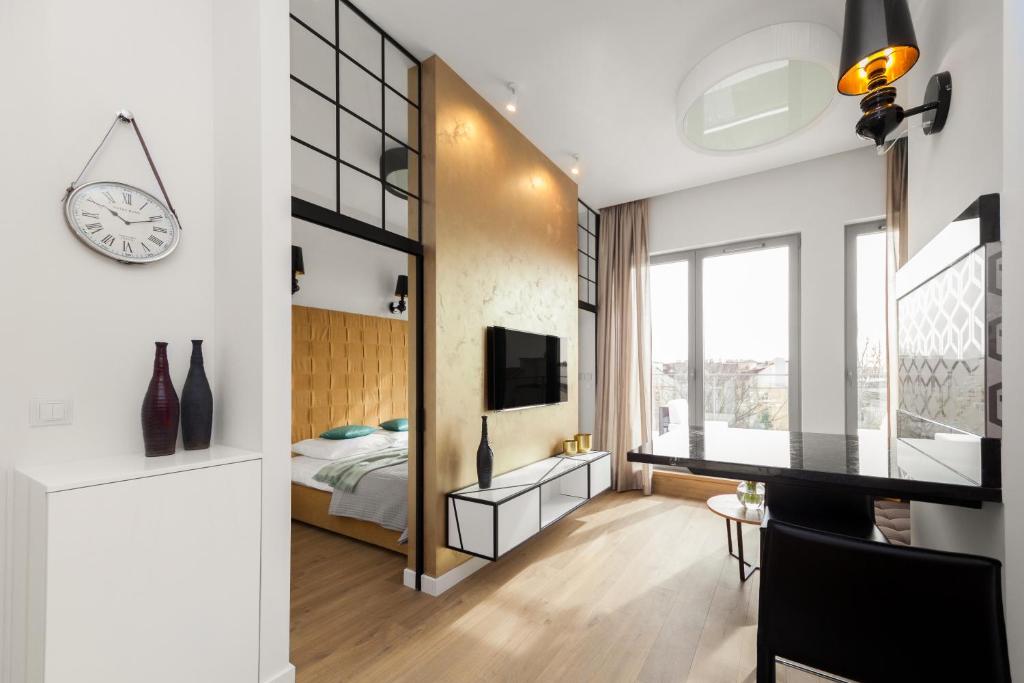 a bedroom with a bed and a clock on a wall at Lofts Cracow Apartments - City Center in Krakow
