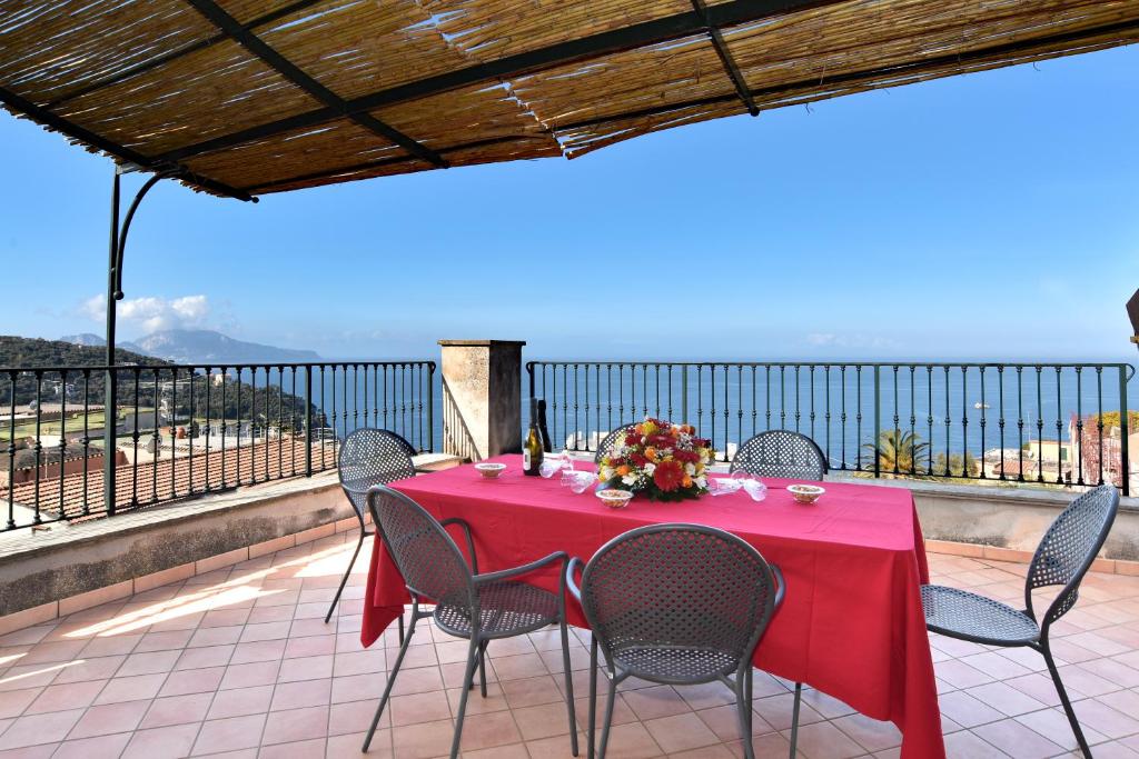 a table with a red tablecloth and chairs on a balcony at La Ciucciara Holiday Homes in Massa Lubrense