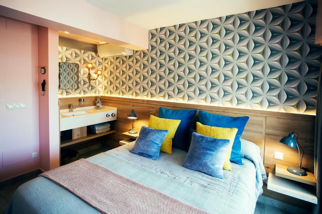 um quarto com uma cama com almofadas azuis e amarelas em Picasso's Birthplace Views em Málaga