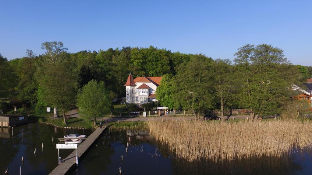 a house sitting on the side of a river at Gast-& Logierhaus Am Rheinsberger See in Rheinsberg