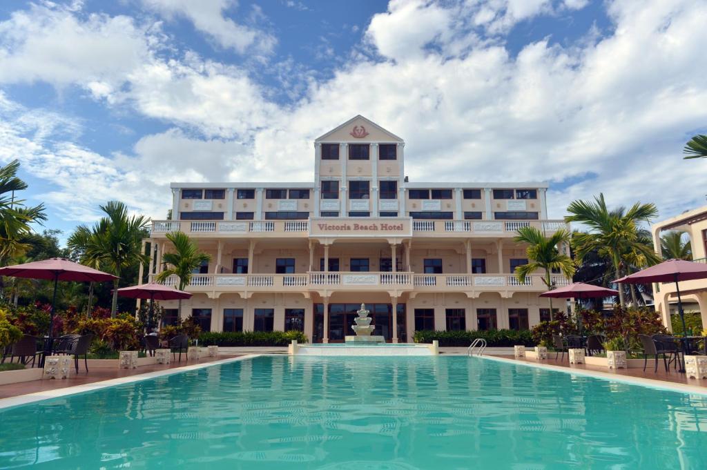 ein großes Gebäude mit einem großen Pool davor in der Unterkunft Victoria Beach Hotel in Toamasina