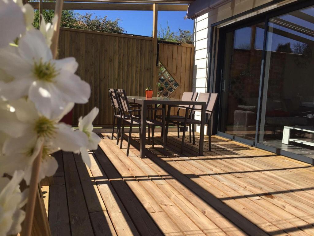 a patio with a table and chairs on a deck at Maison Landreau in Les Épesses