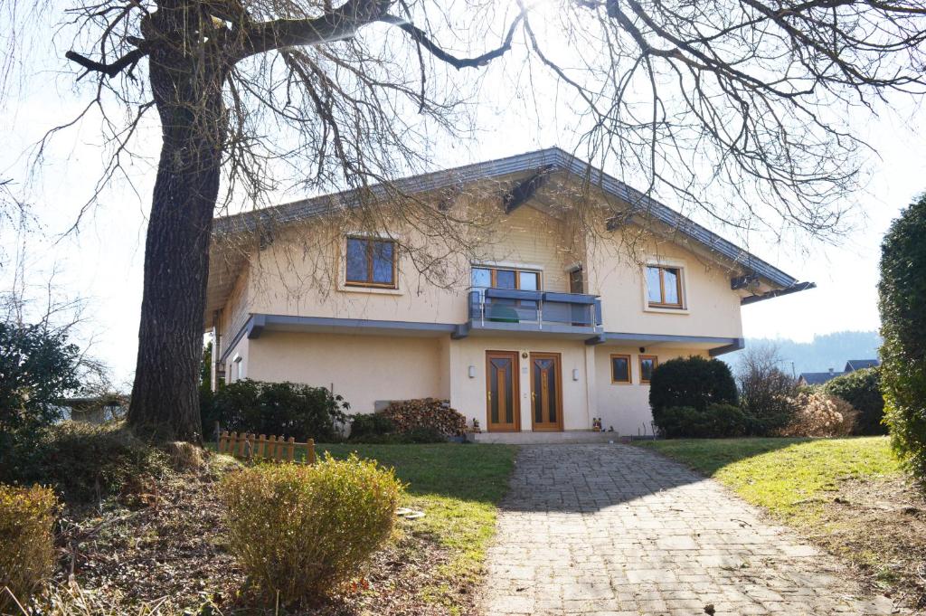 una casa blanca con un árbol y una entrada en Villa Viola, en Moosburg