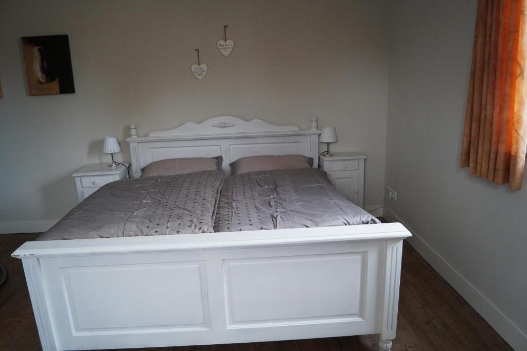 1 cama blanca en una habitación con 2 mesitas de noche en Bed en Breakfast Donkersvoort, en Benk en Donk