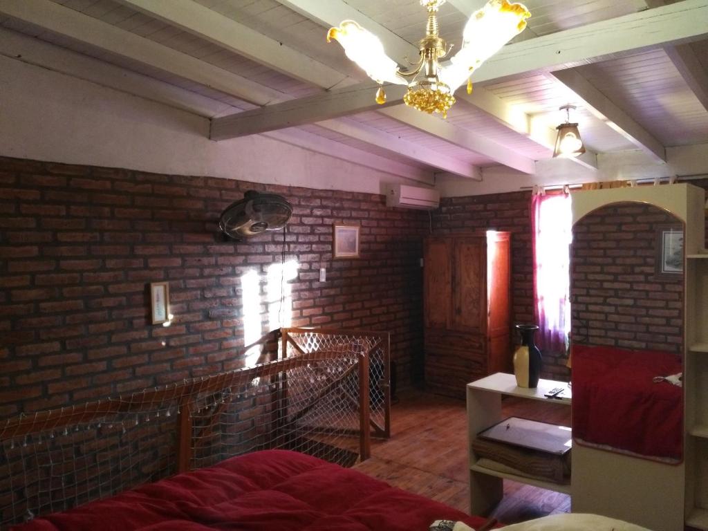 a bedroom with a brick wall and a ceiling at Departamentos Betania in Las Grutas