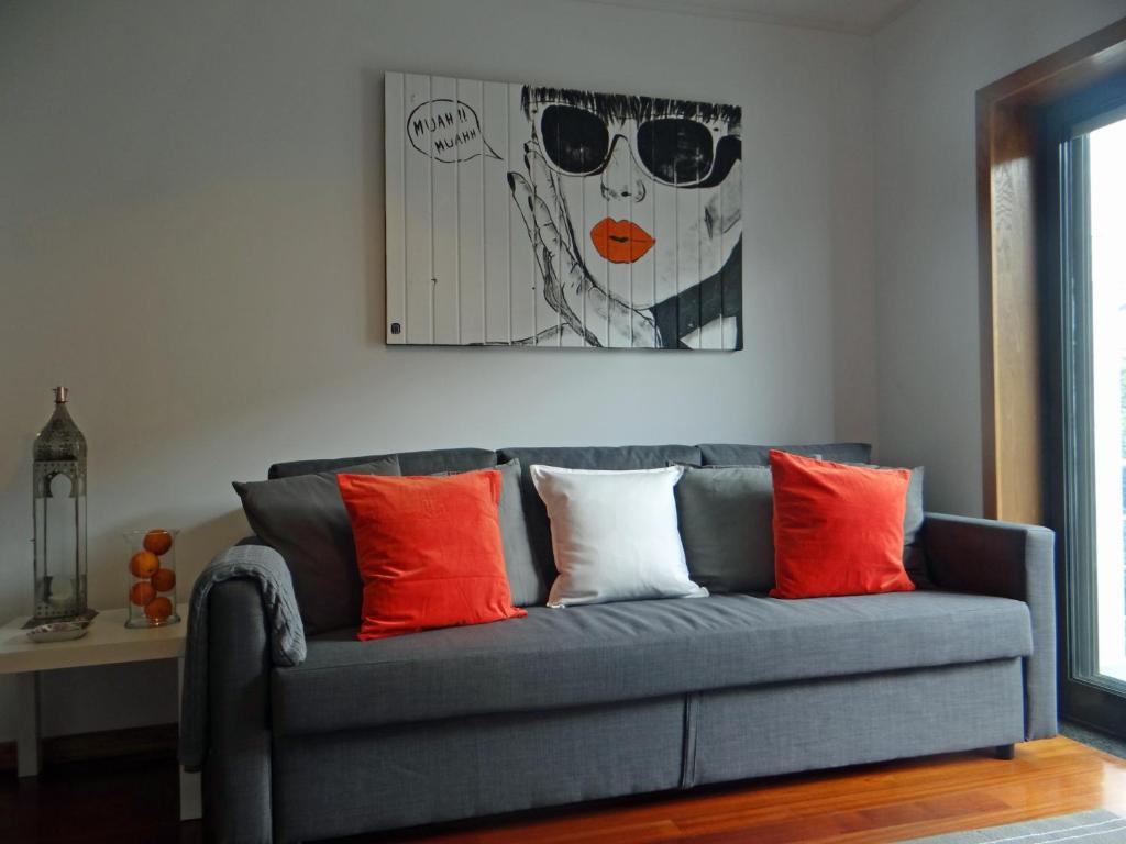a blue couch with orange and white pillows at S. João Porto Apartment in Porto