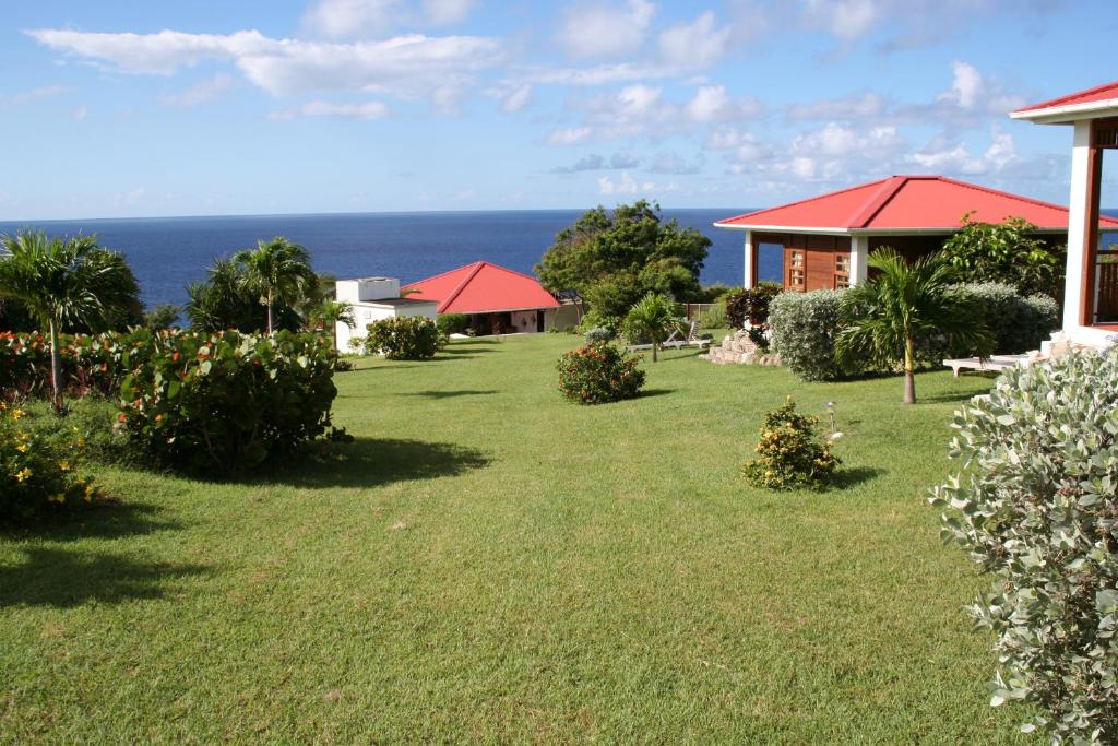 a yard with houses and the ocean in the background at Statia Lodge in Oranjestad