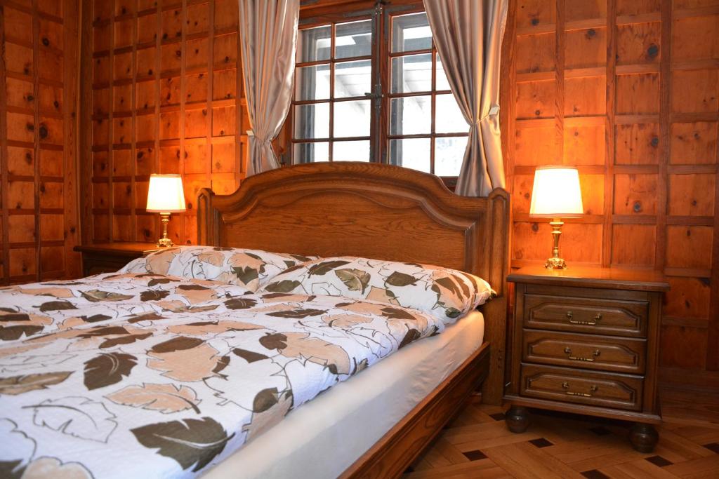 マリアーンスケー・ラーズニェにあるApartman Forstamt Glatzen Kladskaのベッドルーム1室(ベッド1台、ランプ2つ、窓付)