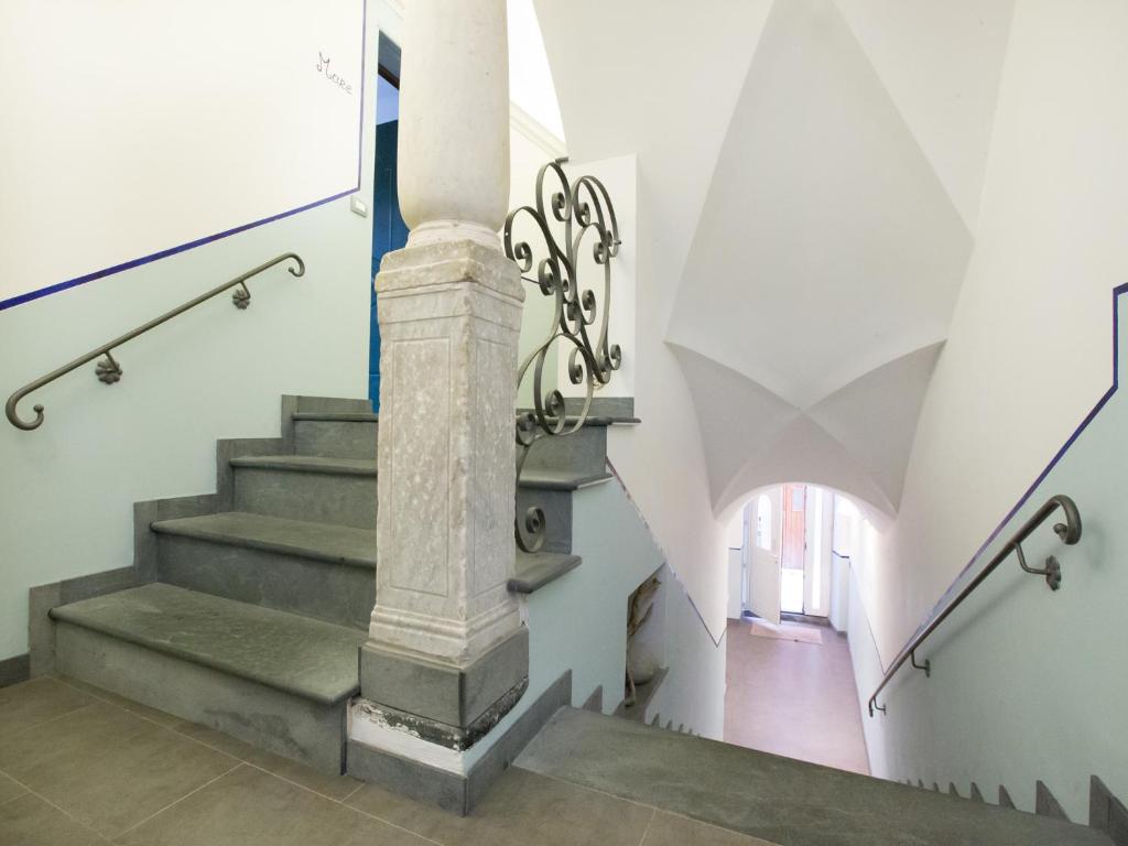 a staircase in a building with a column at A Ca Da Vaniglia in Monterosso al Mare