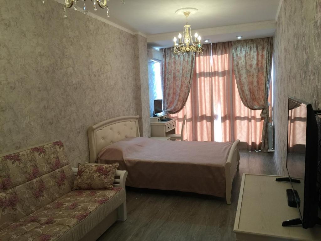 ゲレンジークにあるАпартаменты на Крымской 19 с видом на мореのベッドルーム1室(ベッド1台、ソファ、シャンデリア付)