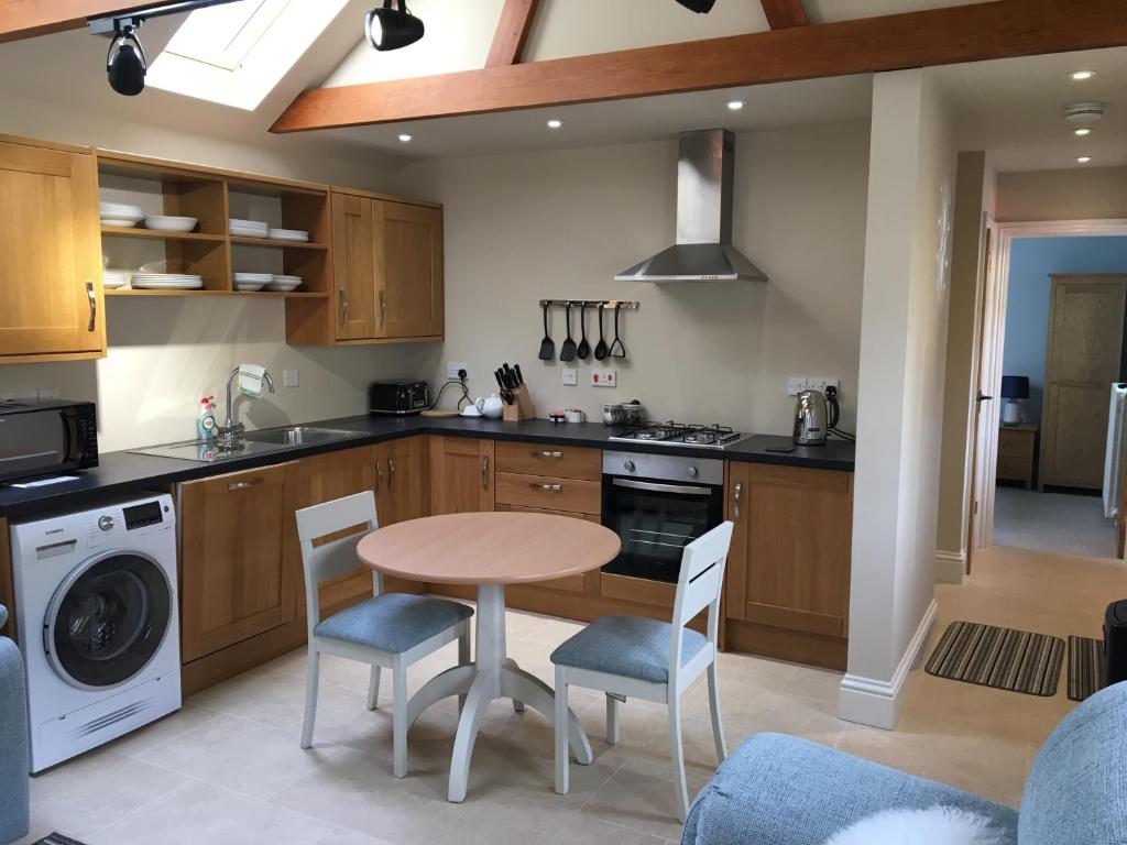 a kitchen with a table and chairs in a kitchen at The Old Stables in Hinton Charterhouse