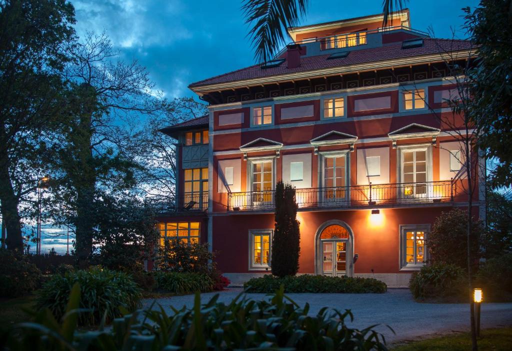 ein großes Haus in der Nacht mit eingeschaltetem Licht in der Unterkunft Casona de La Paca in Cudillero