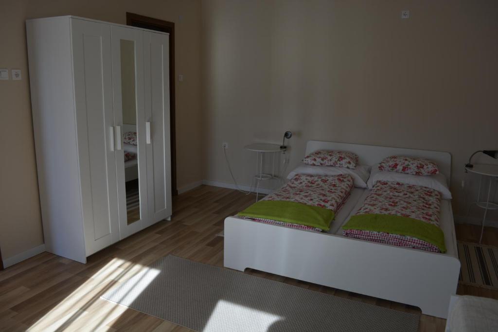 a bedroom with two beds and a mirror at Napsugár Vendégház in Egerszalók