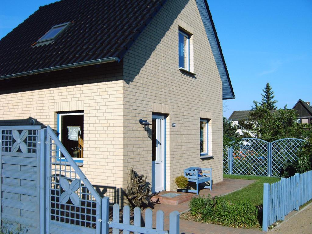 a house with a white fence in front of it at Großes, einzeln stehendes Ferienhaus "Undine", ruhige Lage, Terrasse, Parkplatz, Fahrradhäuschen abschließbar, Nähe zur Altstadt und 600 m zum Müritz - Strand in Waren