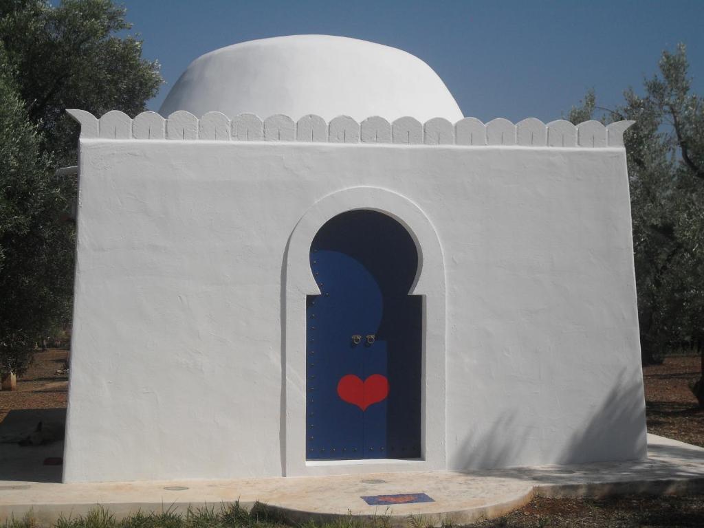 un edificio con una puerta con un corazón pintado en él en Case d'Artista, en Savelletri di Fasano