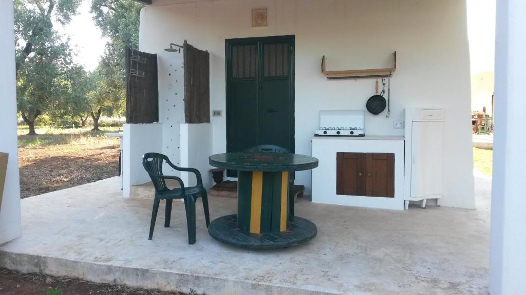 a kitchen with a table and a chair and a stove at Case d'Artista in Savelletri di Fasano