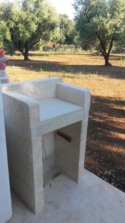 a white stone bench sitting on the side of a field at Case d'Artista in Savelletri di Fasano
