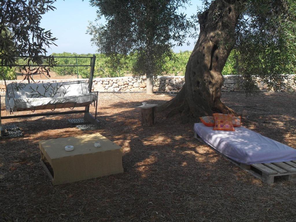 a tree with a mattress and a bench under it at Case d'Artista in Savelletri di Fasano
