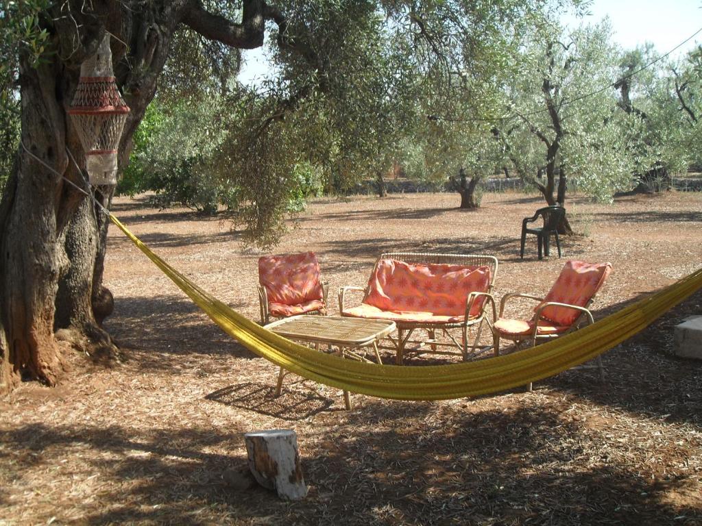 two chairs and a hammock under a tree at Case d'Artista in Savelletri di Fasano