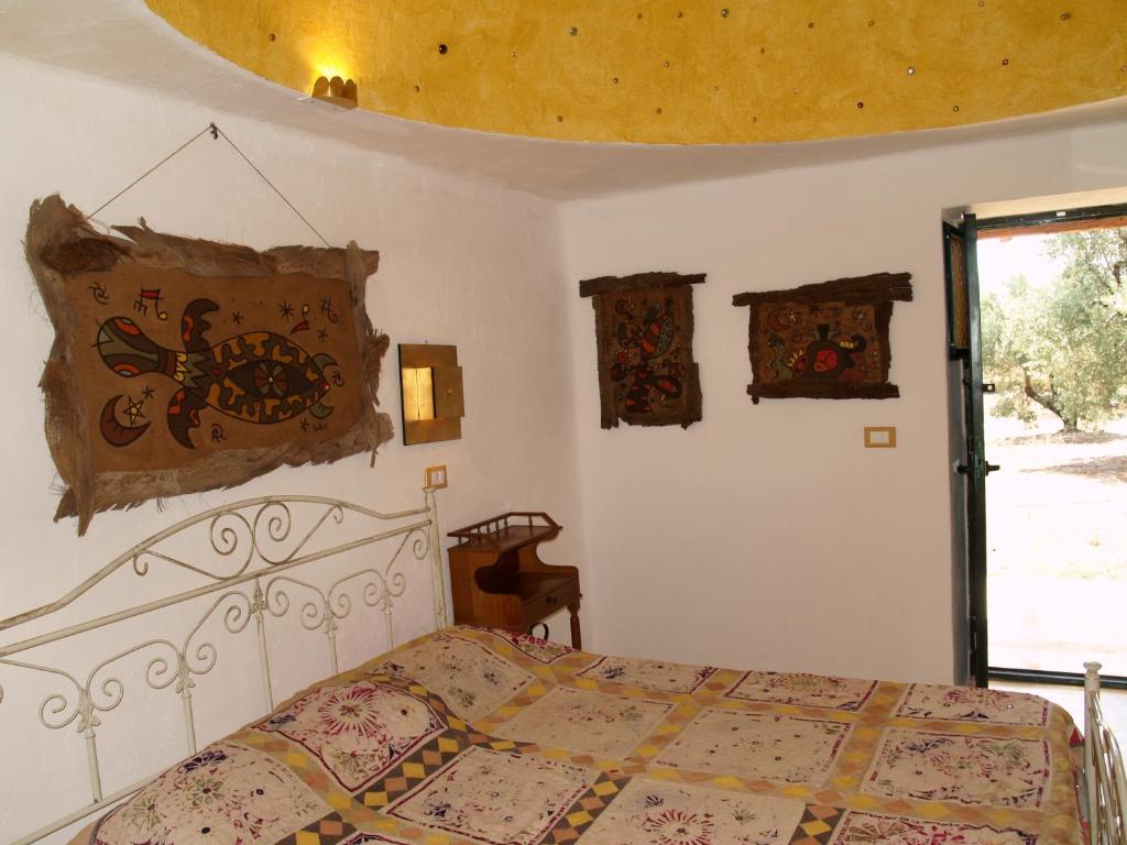 a bedroom with a bed and some pictures on the wall at Case d'Artista in Savelletri di Fasano
