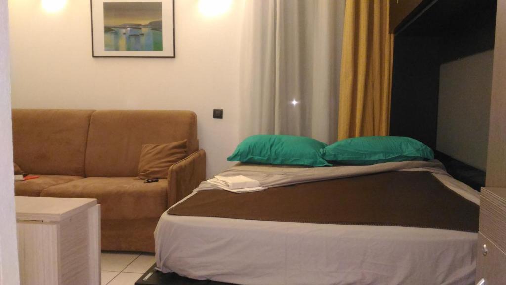 - un lit avec 2 oreillers verts et un canapé dans l'établissement Californie Appartement, à Nice