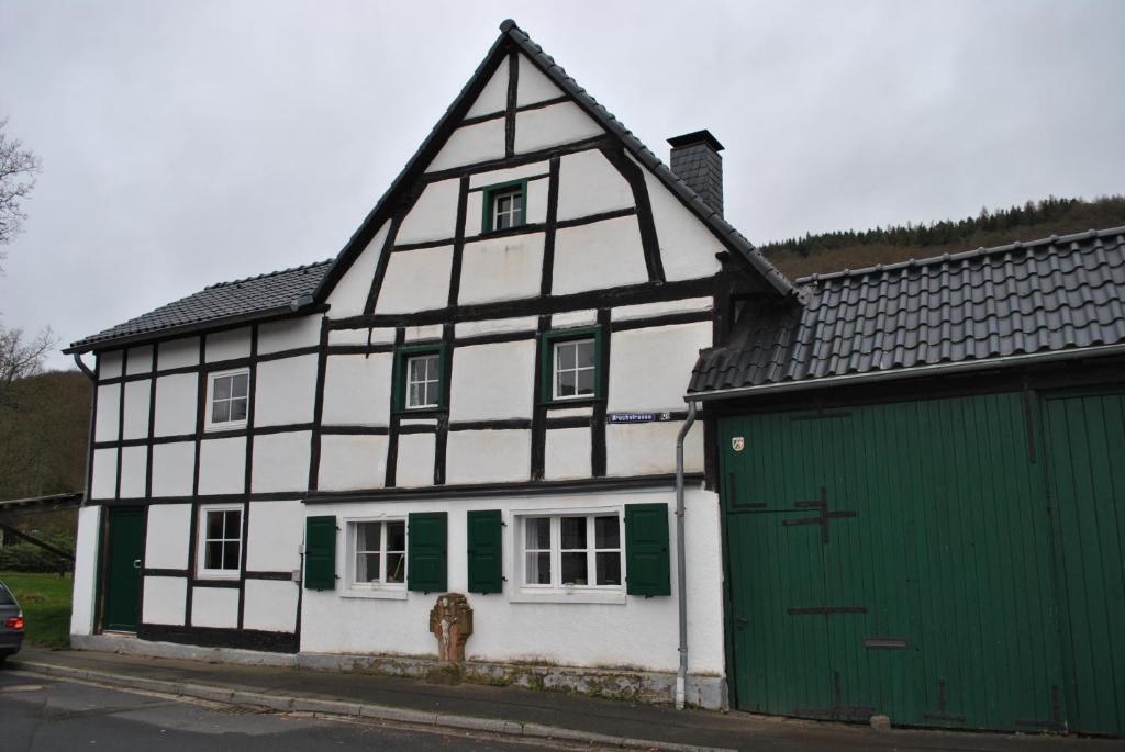 a white and green house with a green garage at Ferienwohnungen Türmchen in Gemünd