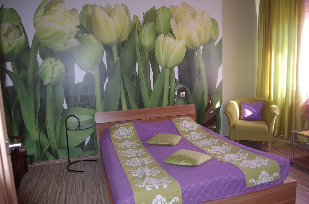 a bedroom with a bed and a mural of flowers at Kate Sea Apartment in Pärnu