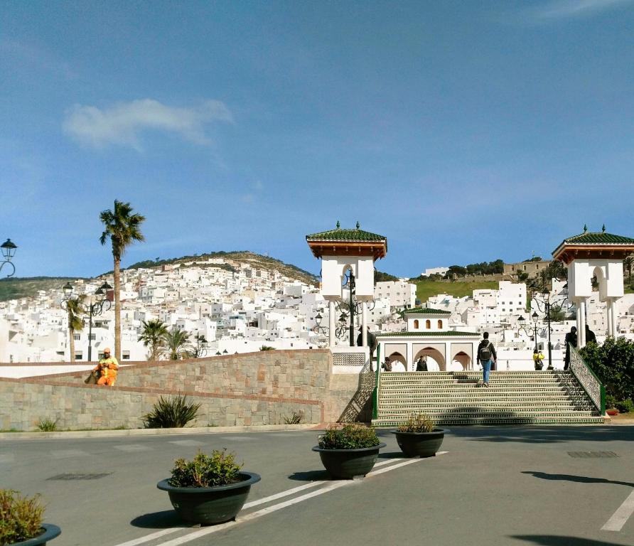 un edificio con scale e palme su una collina di Riad Khmisa a Tétouan