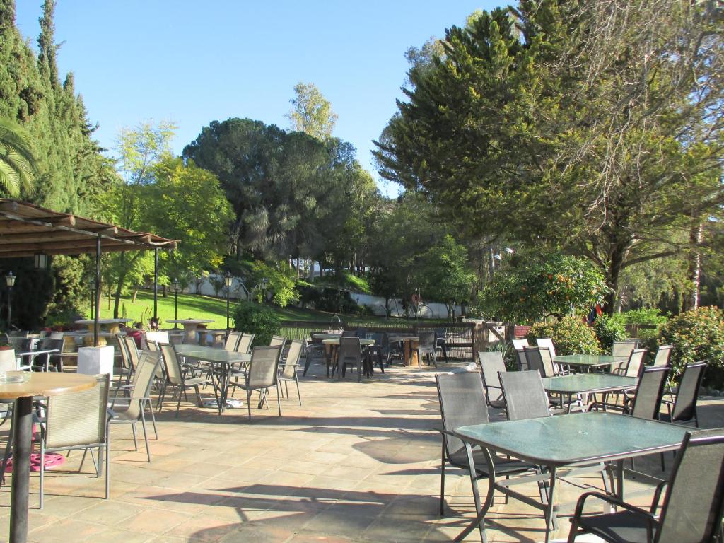 an outdoor patio with tables and chairs and trees at Finca la Mota in Alhaurín el Grande