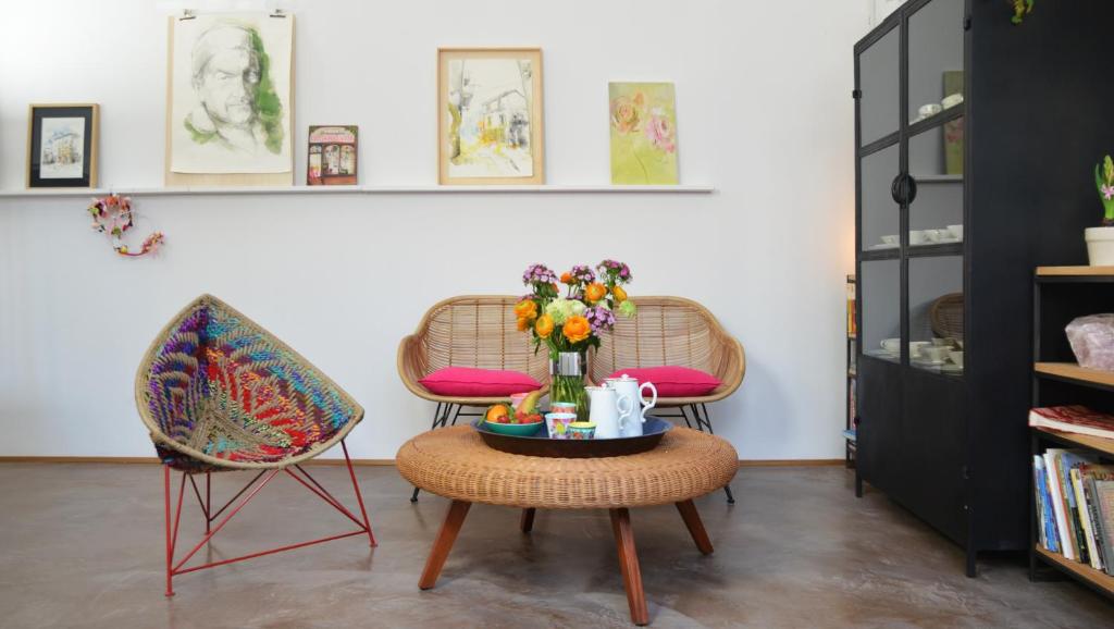カロルツィオコルテにあるPicobello Zimmer & Atelierの椅子2脚とテーブル(花付)が備わるお部屋