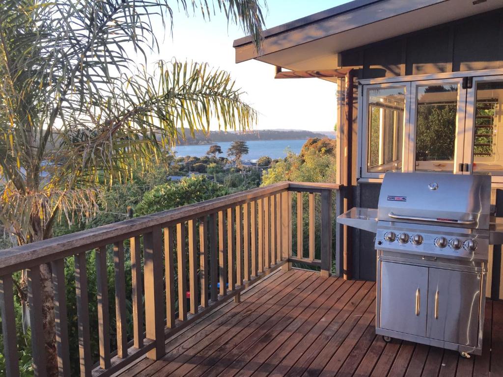 a grill on a deck with a view of the water at Waiheke Island Oneroa in Oneroa