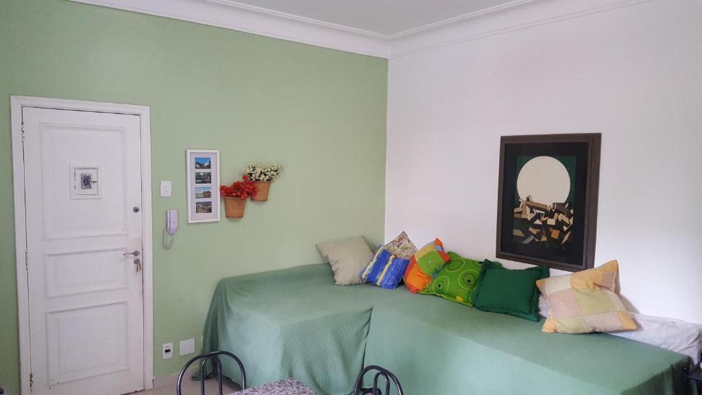 1 dormitorio con cama y espejo en la pared en Temporada Rio Studio Lily 2 - Perto do Cristo e de Copacabana, en Río de Janeiro