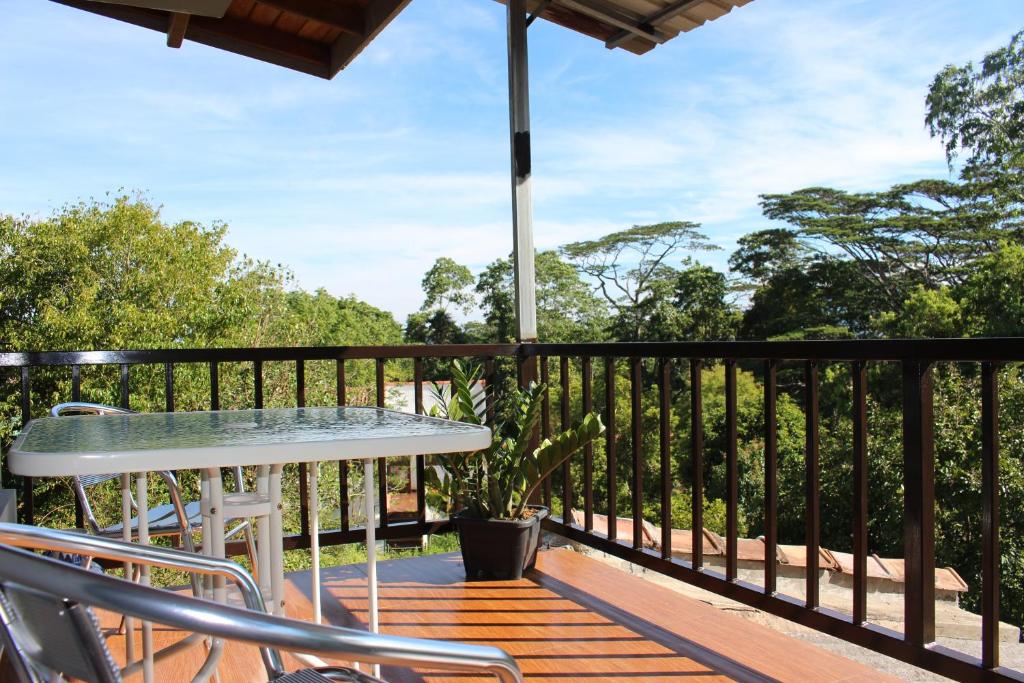 a balcony with a table and chairs on a deck at e-stay Hanthana Kandy in Kandy