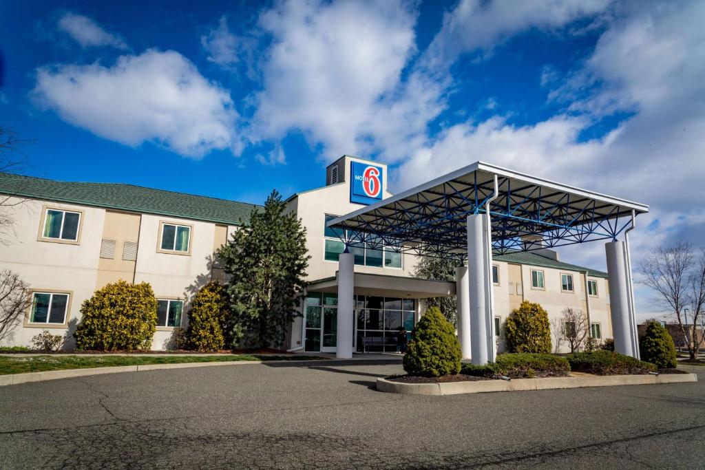 a building with a gas station with a sign on it at Motel 6-Pottstown, PA in Pottstown
