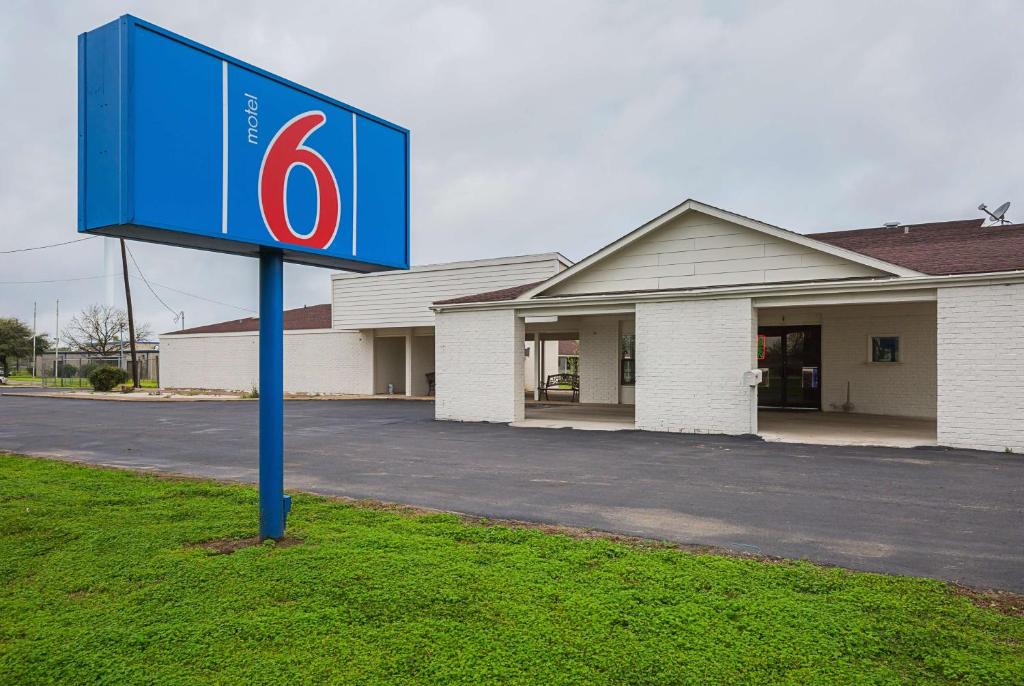 a blue sign in front of a building at Motel 6-Madisonville, TX in Madisonville
