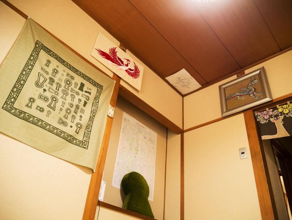 una habitación con un cartel en la pared y un estante en Yamabe, en Tenri